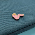 Worm wooden pin with a yellow head on a blue textured fabric background