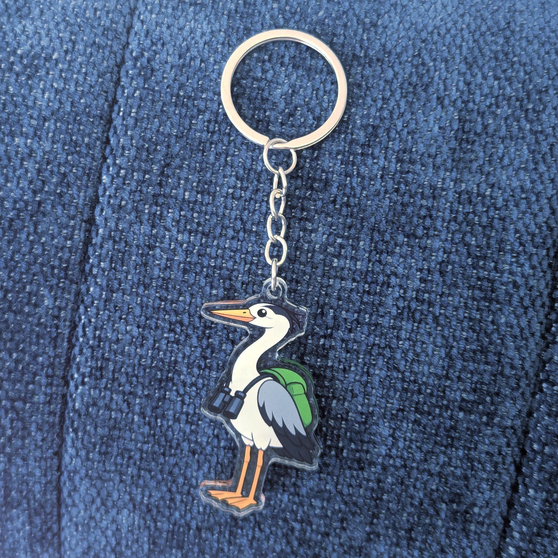 Keychain with a heron design on a blue denim background