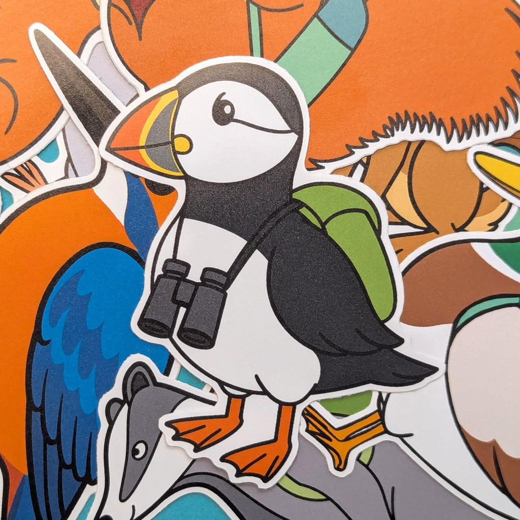 Sticker of an Atlantic puffin with binoculars and a backpack on an orange background