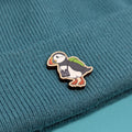 Puffin wooden pin on a textured teal fabric background