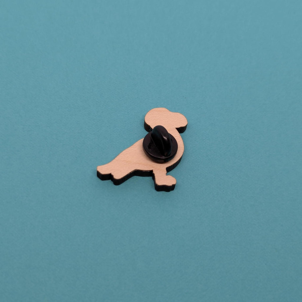 Back of seagull wooden pin badge on blue background
