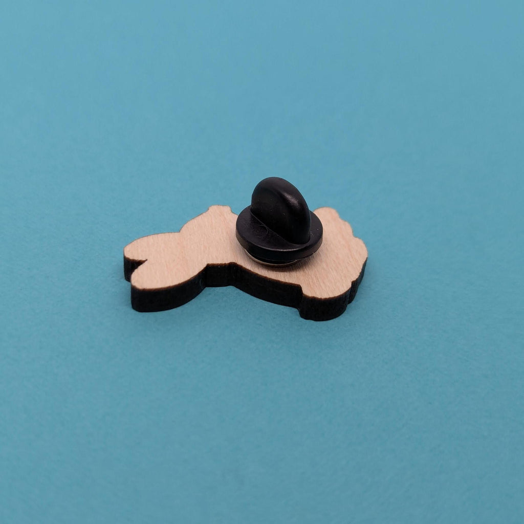 Back of wooden hare pin badge on a blue background