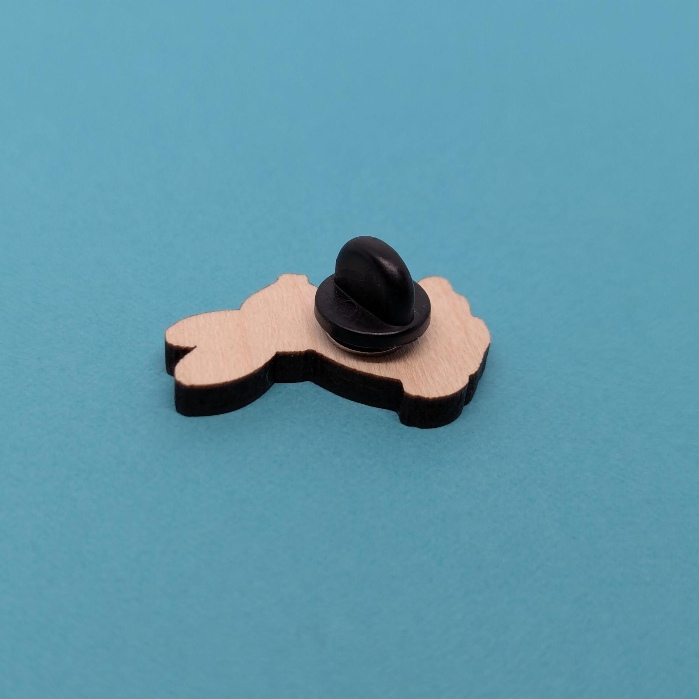 Back of wooden hare pin badge on a blue background