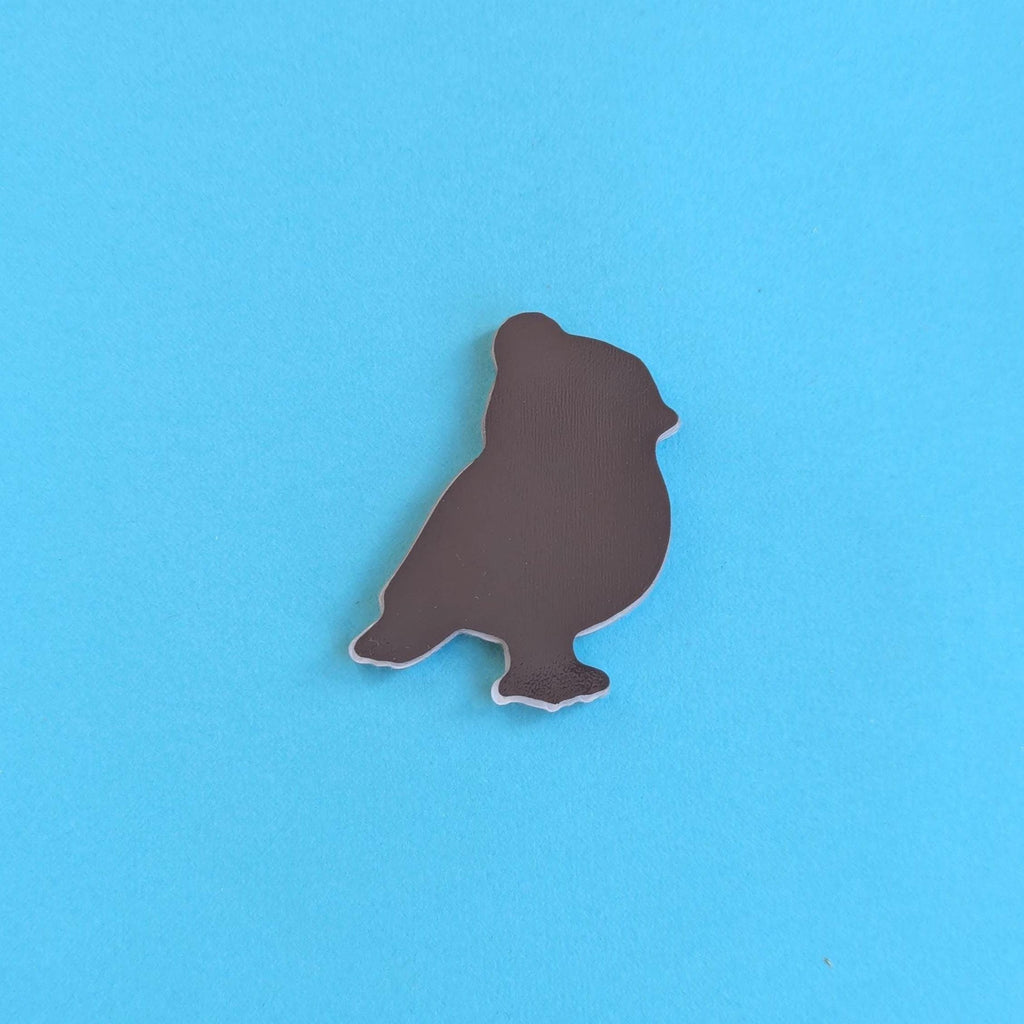 Back view of a robin in a beanie hat fridge magnet on a blue background
