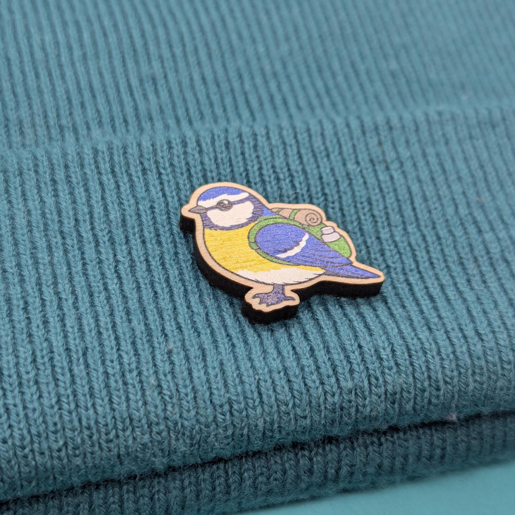 blue tit bird pin on a textured teal fabric background