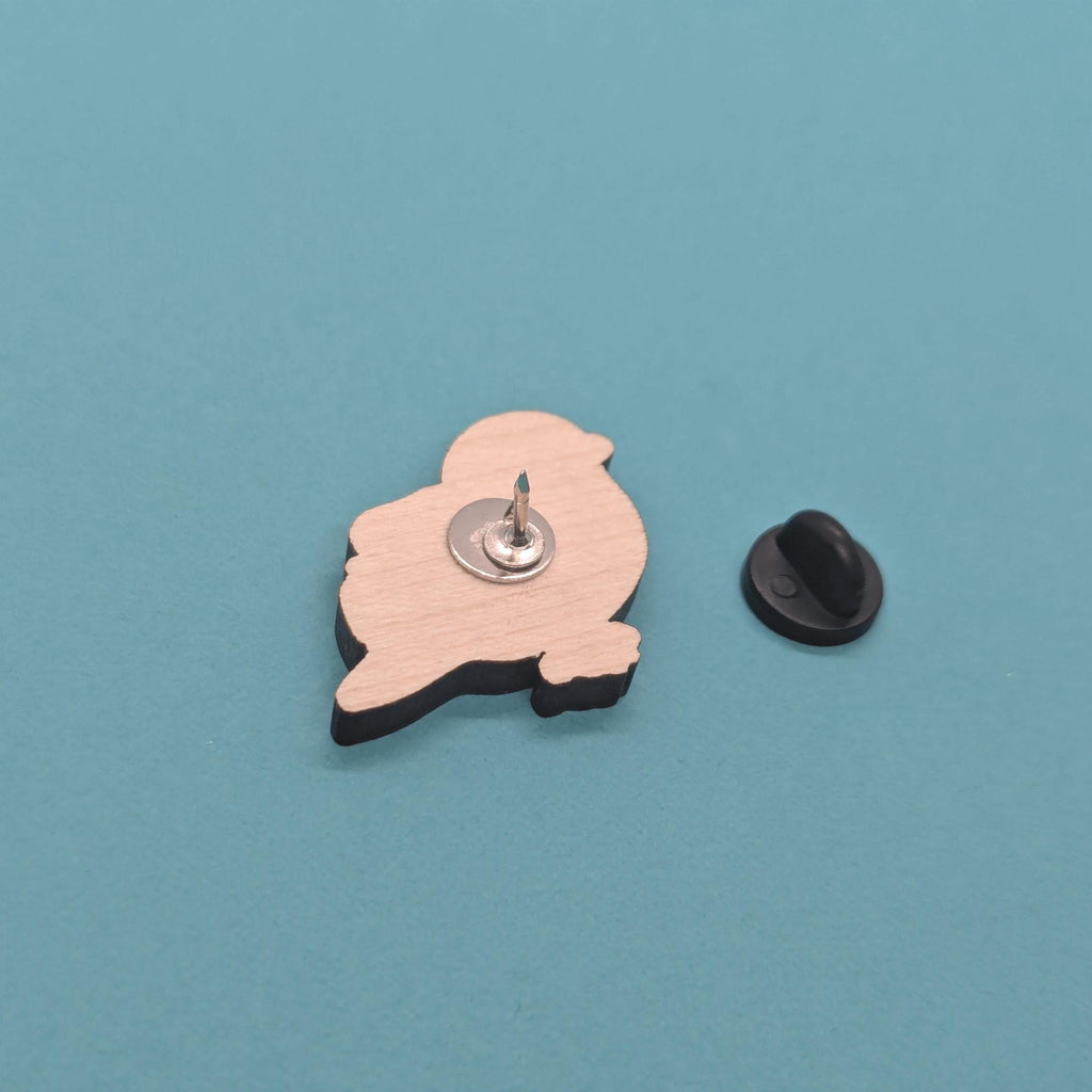 Wooden blue tit pin  back on a blue background