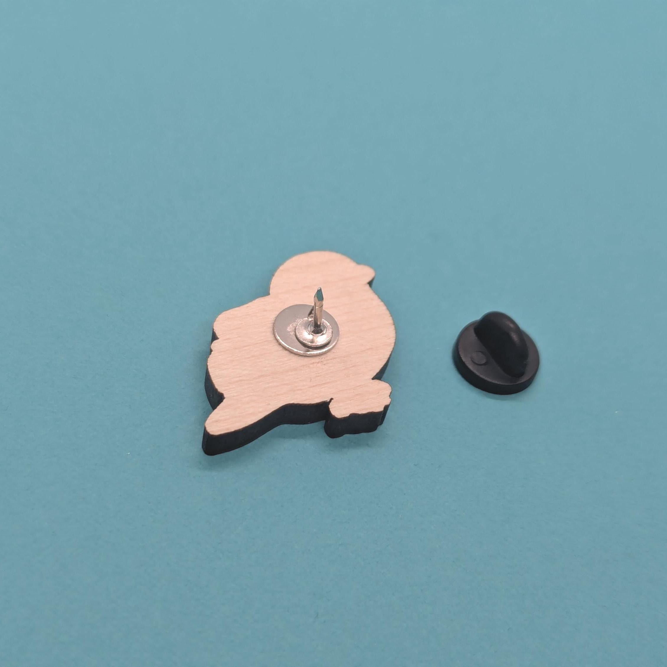 Wooden blue tit pin  back on a blue background