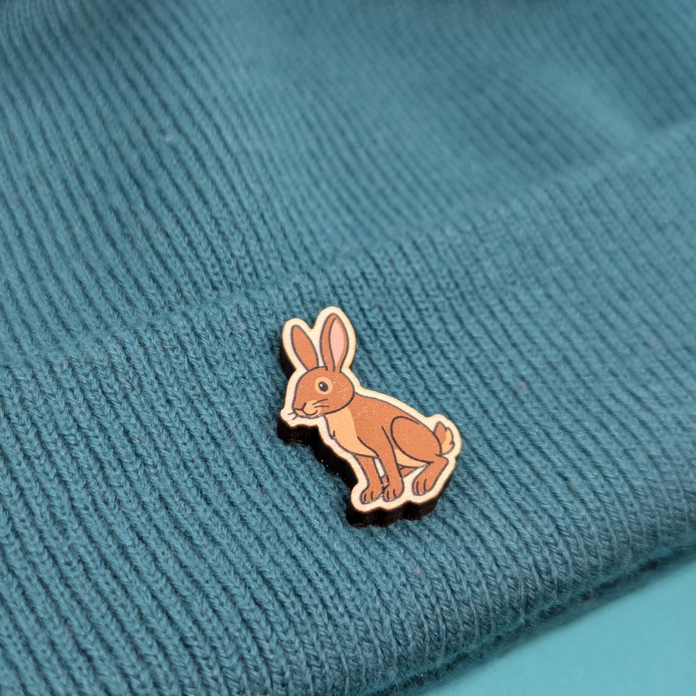 Brown rabbit wooden pin on a textured blue fabric background