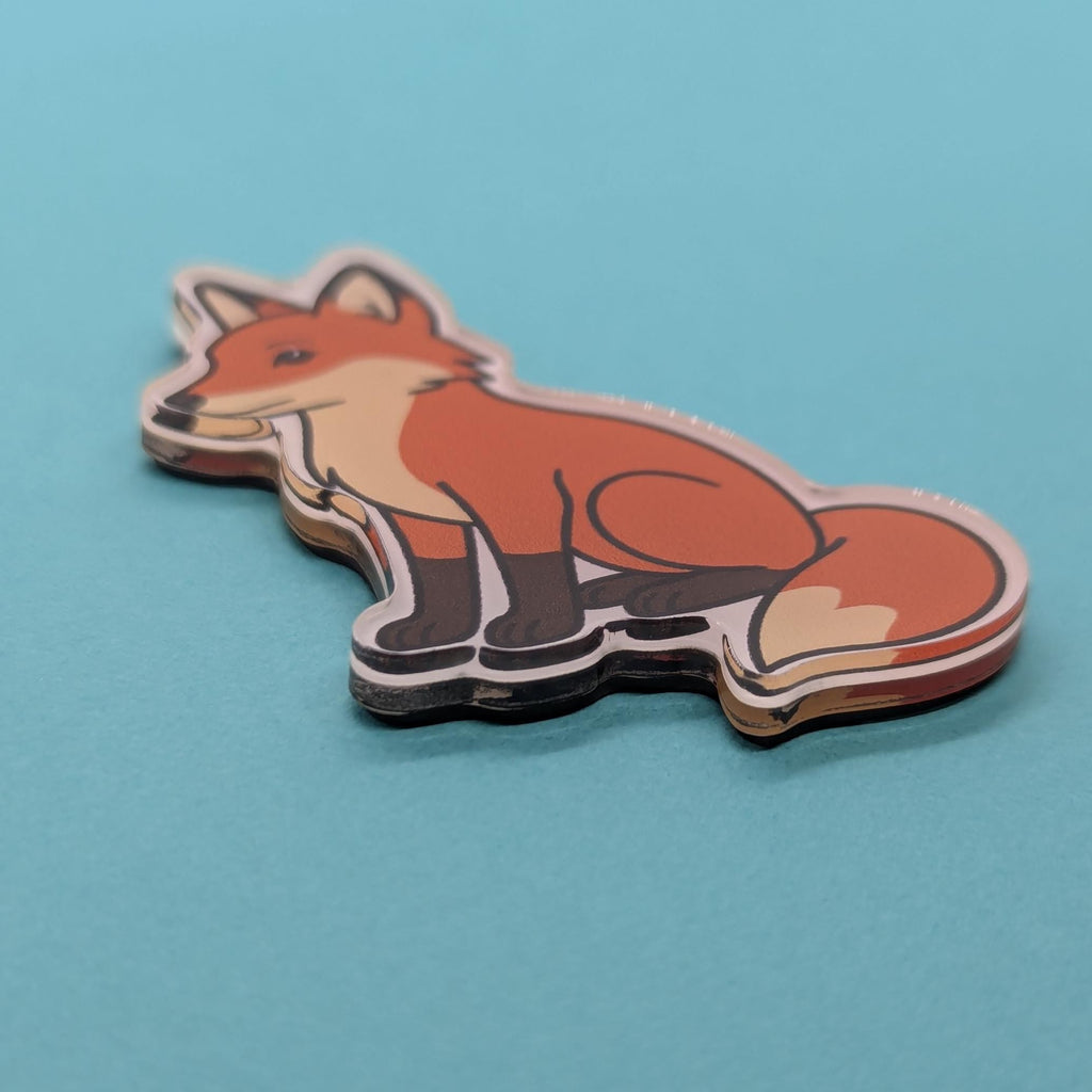close up of a red fox acrylic fridge magnet on a blue background