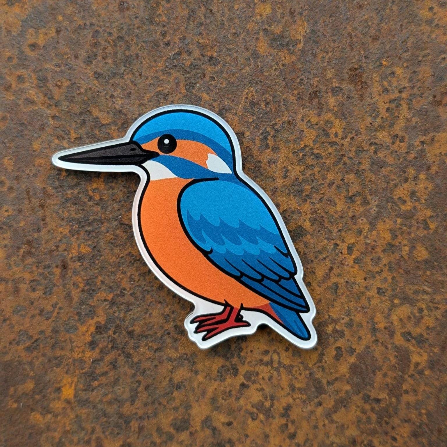 Fridge magnet of a blue and orange kingfisher bird on a rusty metal background