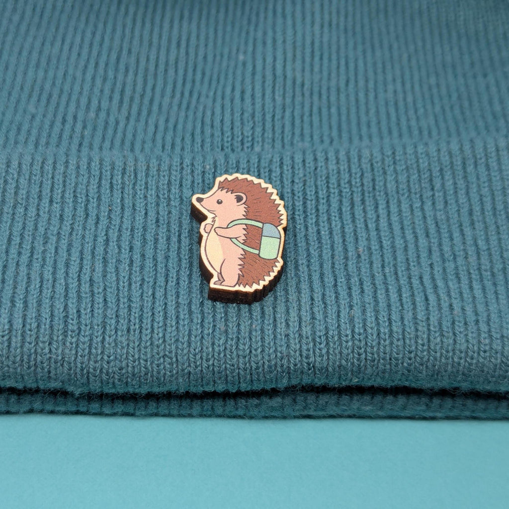 Hedgehog wooden pin on a textured blue fabric background