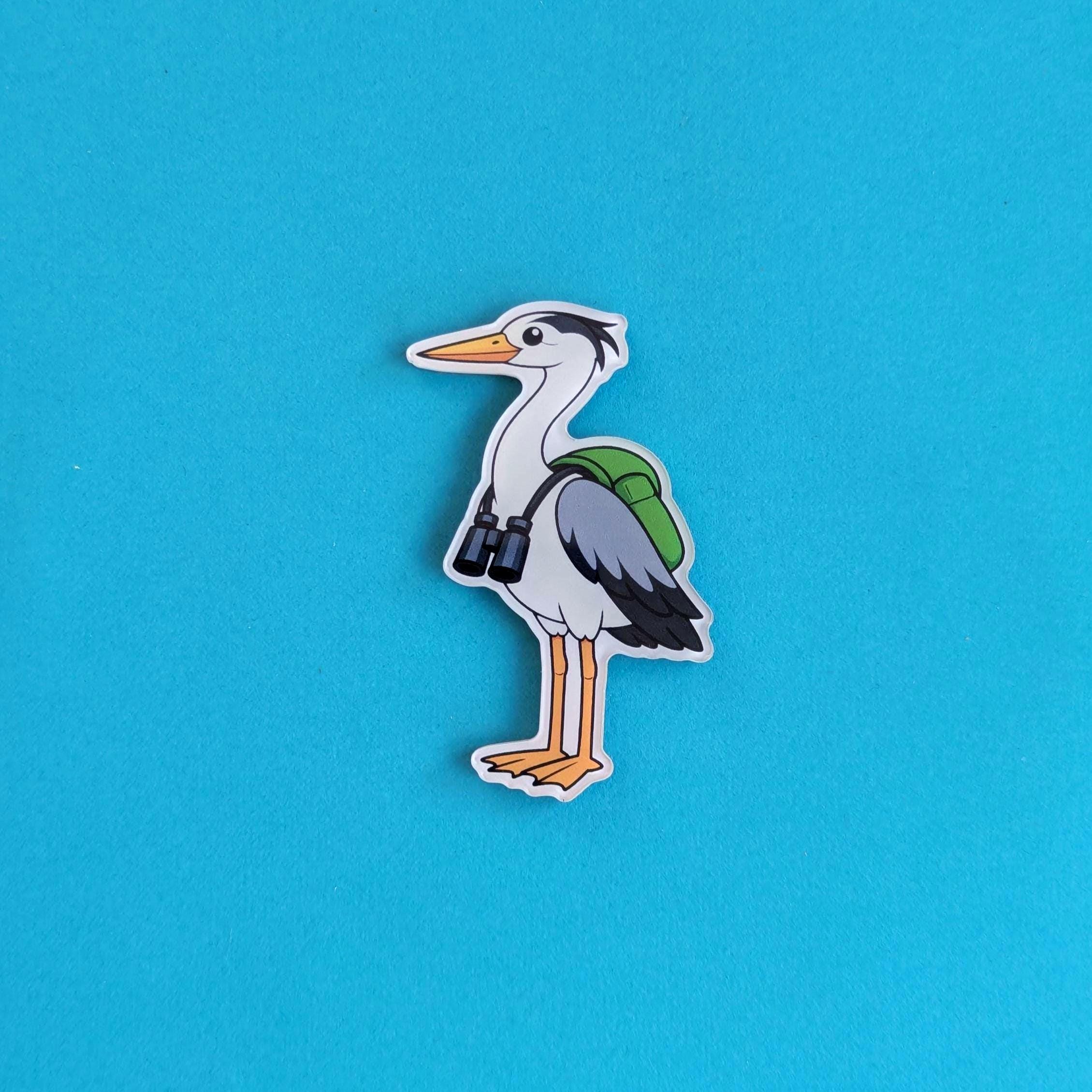 Refrigerator magnet of a cartoon heron with a backpack on a blue background