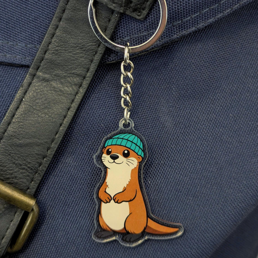 Keychain with an otter wearing a blue hat attached to a bag.