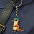 Keychain with an otter wearing a blue hat attached to a bag.