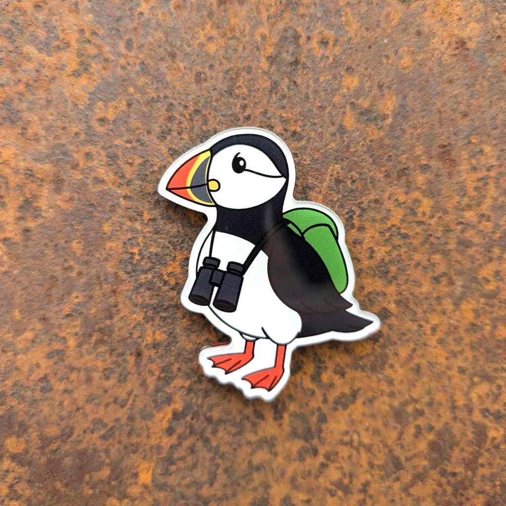 Puffin fridge magnet with a backpack and binoculars on a rusty metal background
