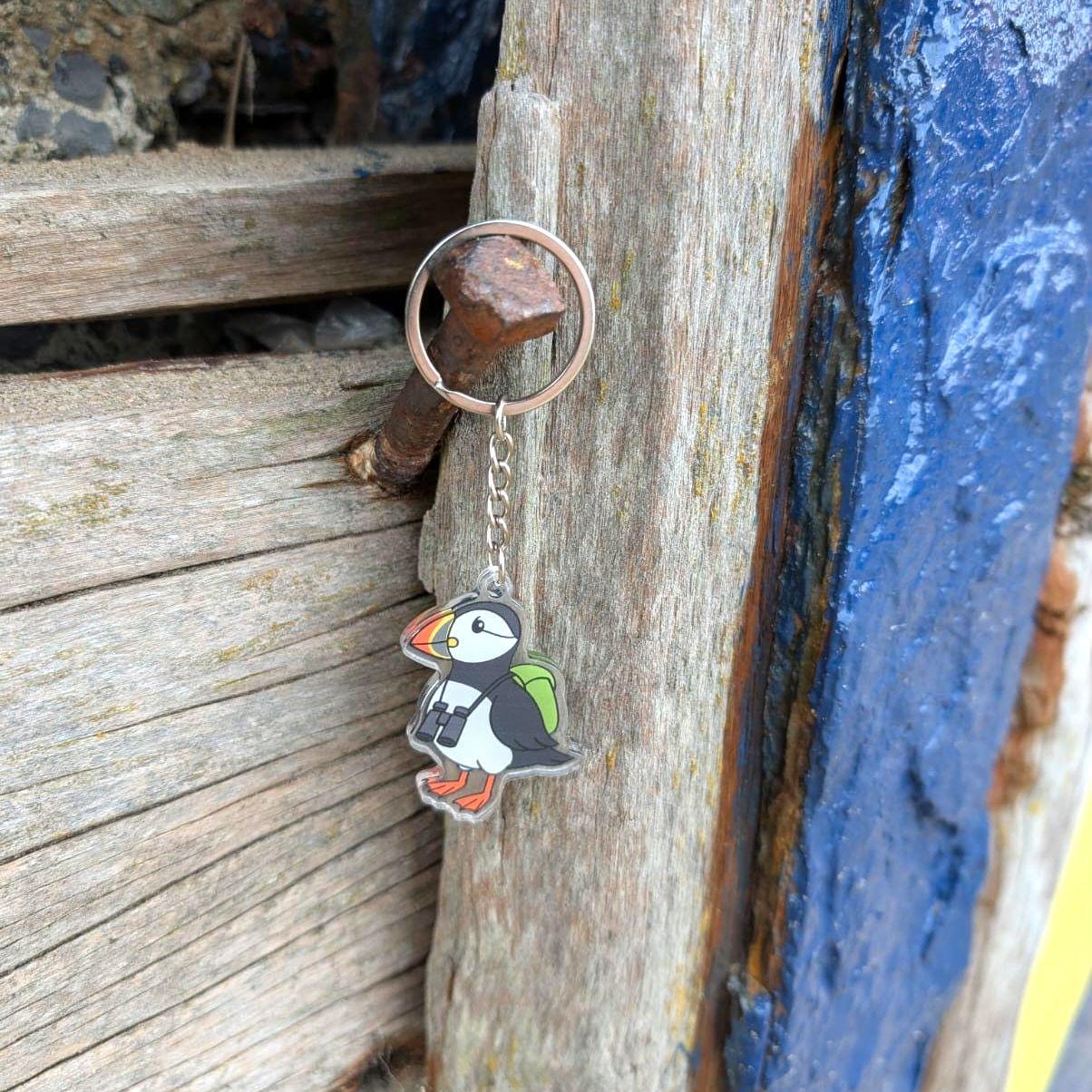 Puffin keychain attached to a wooden post with a blue background