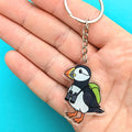 Puffin keychain held in a hand with a blue background