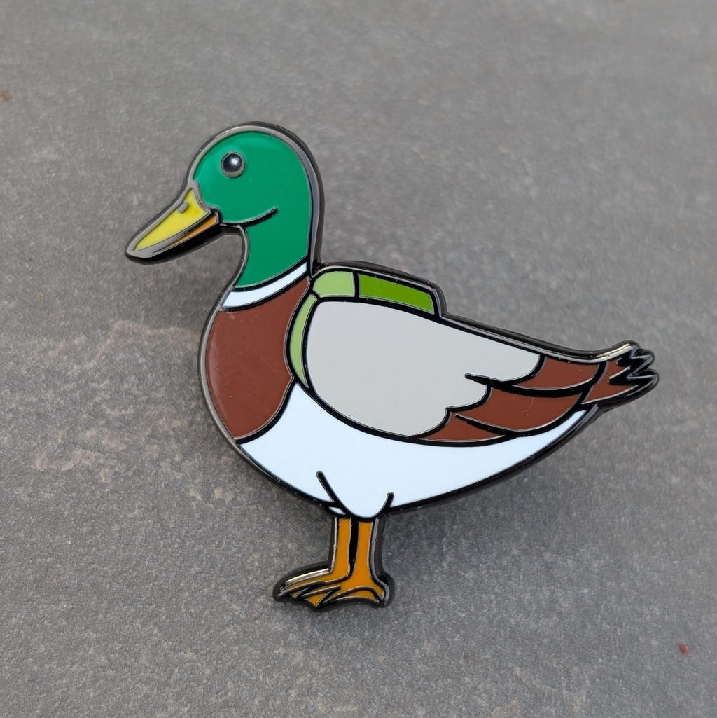 Duck enamel pin on a gray background