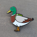 Duck enamel pin on a gray background