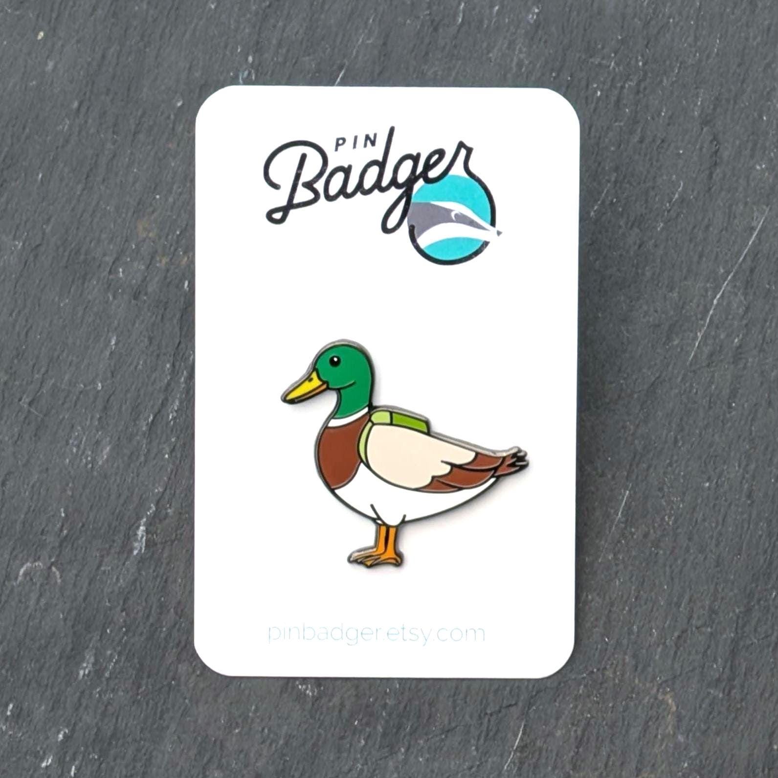 Duck pin on a white card with 'Pin Badger' branding on a dark gray background