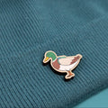 Duck wooden pin on a textured teal fabric background