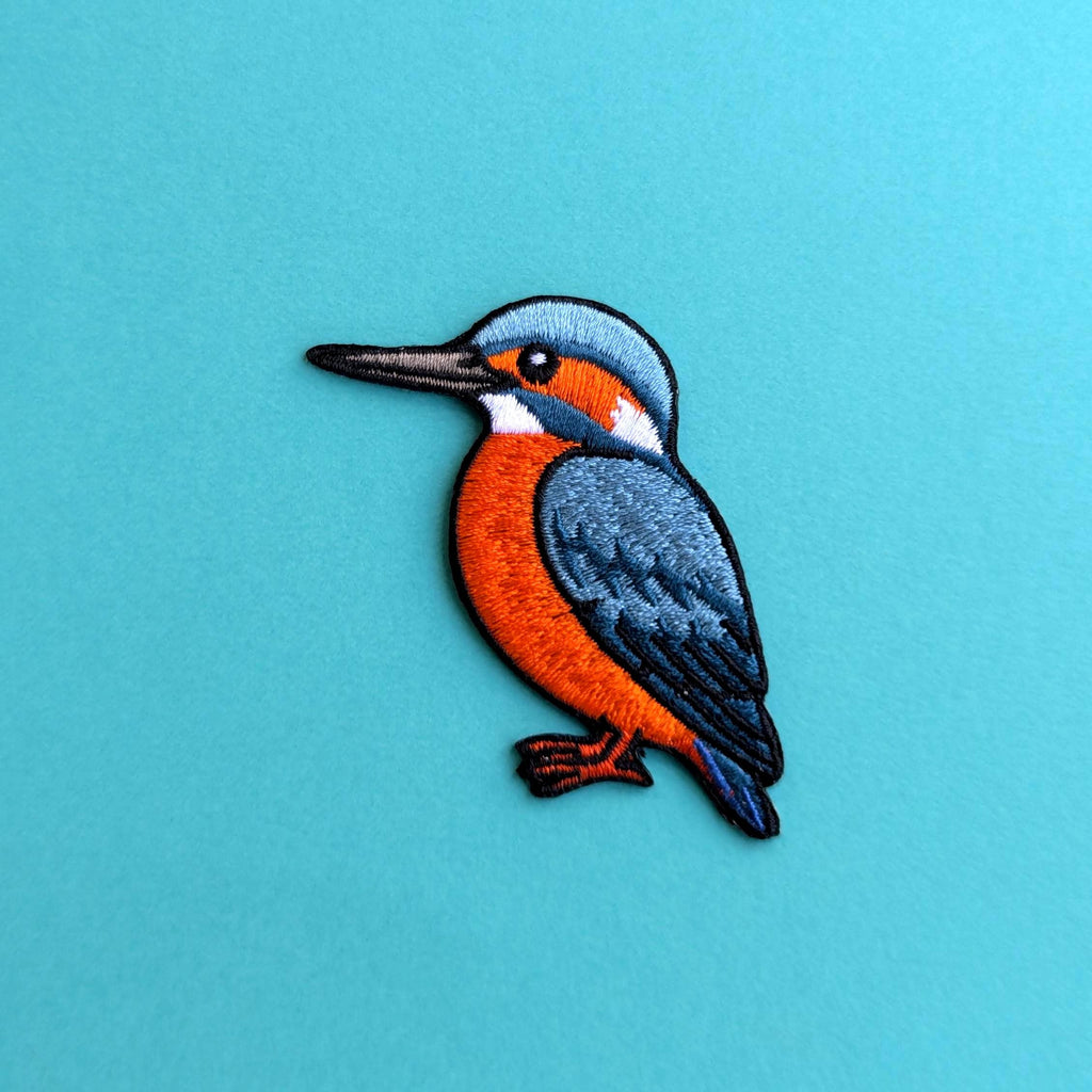 Embroidered patch of a kingfisher bird on a blue background