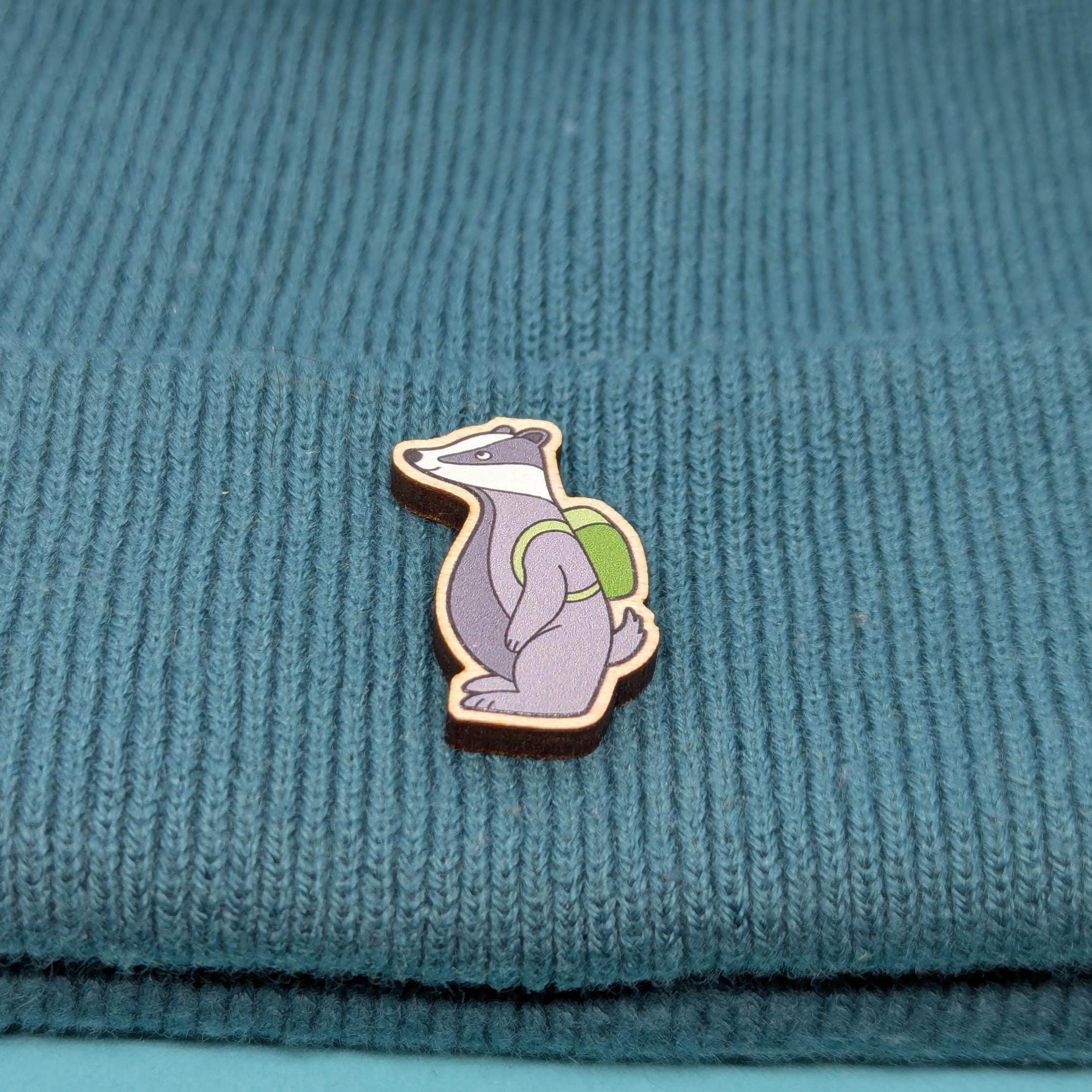 Wooden pin of badger on a textured teal fabric back