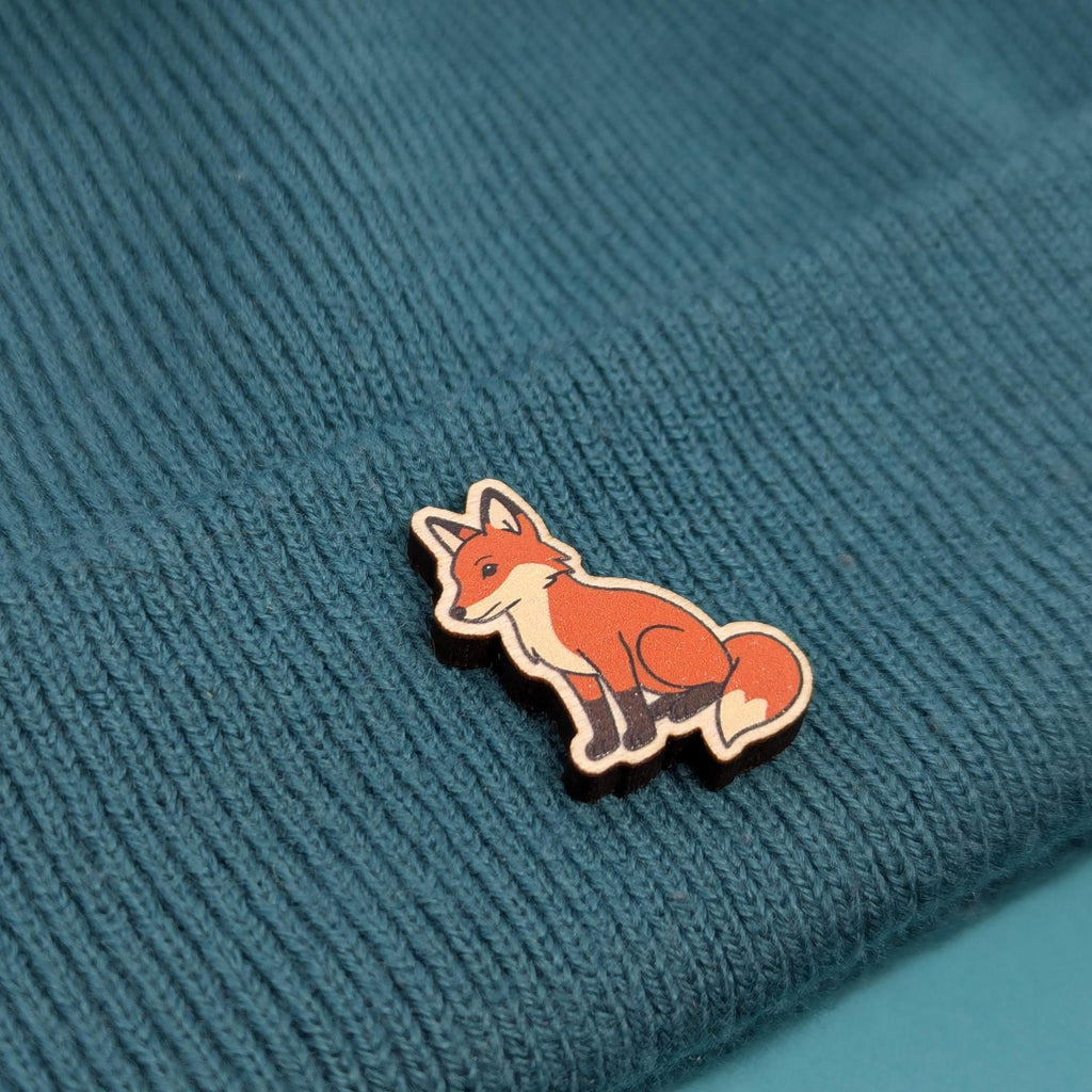 Fox wooden pin on a textured blue fabric background