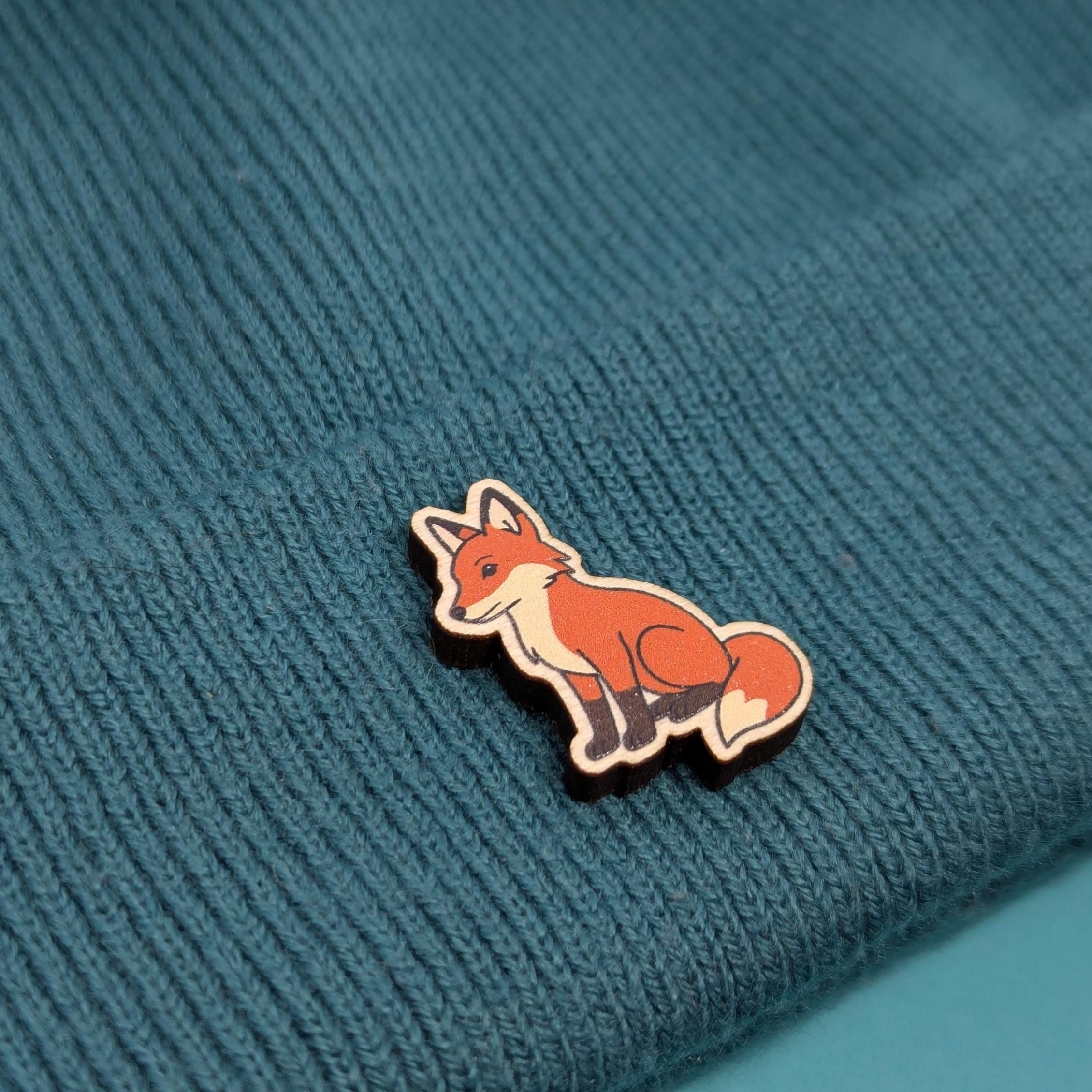 Fox wooden pin on a textured blue fabric background