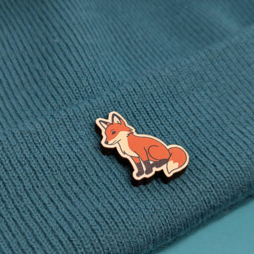 Fox wooden pin on a textured blue fabric background