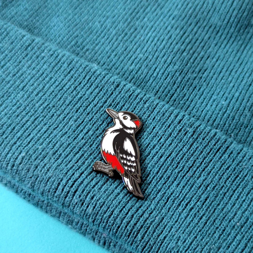 woodpecker pin on a textured blue fabric background
