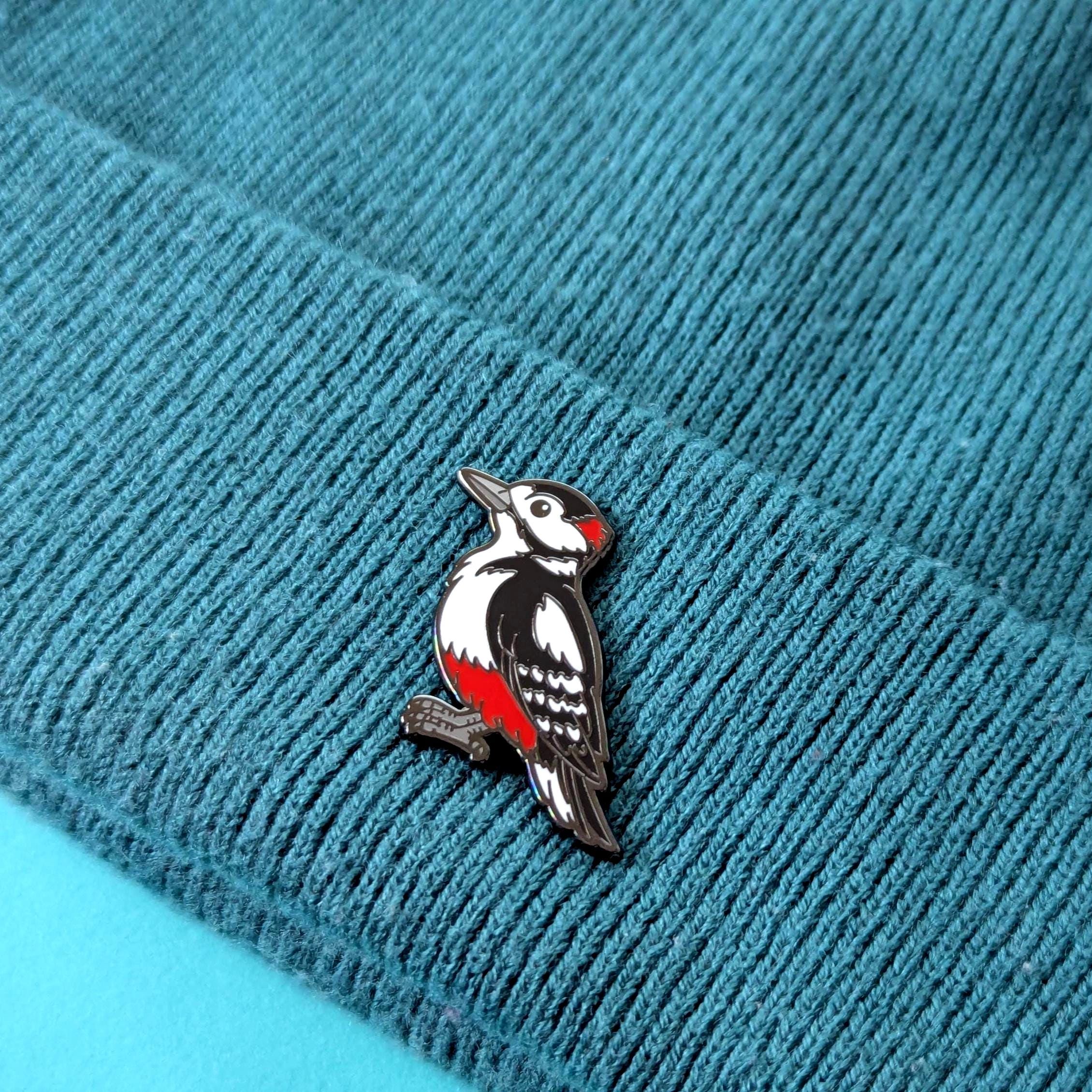 woodpecker pin on a textured blue fabric background