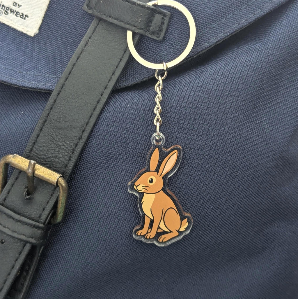 Keychain with a rabbit design attached to a navy bag.