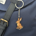 Keychain with a rabbit design attached to a navy bag.