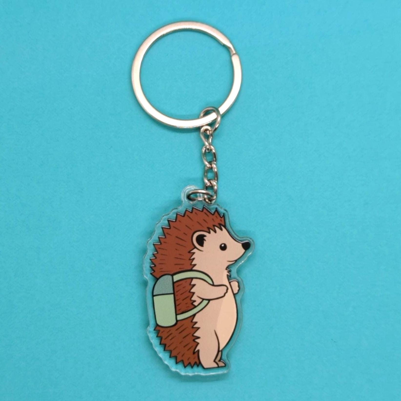Hedgehog keychain with a backpack on a blue background