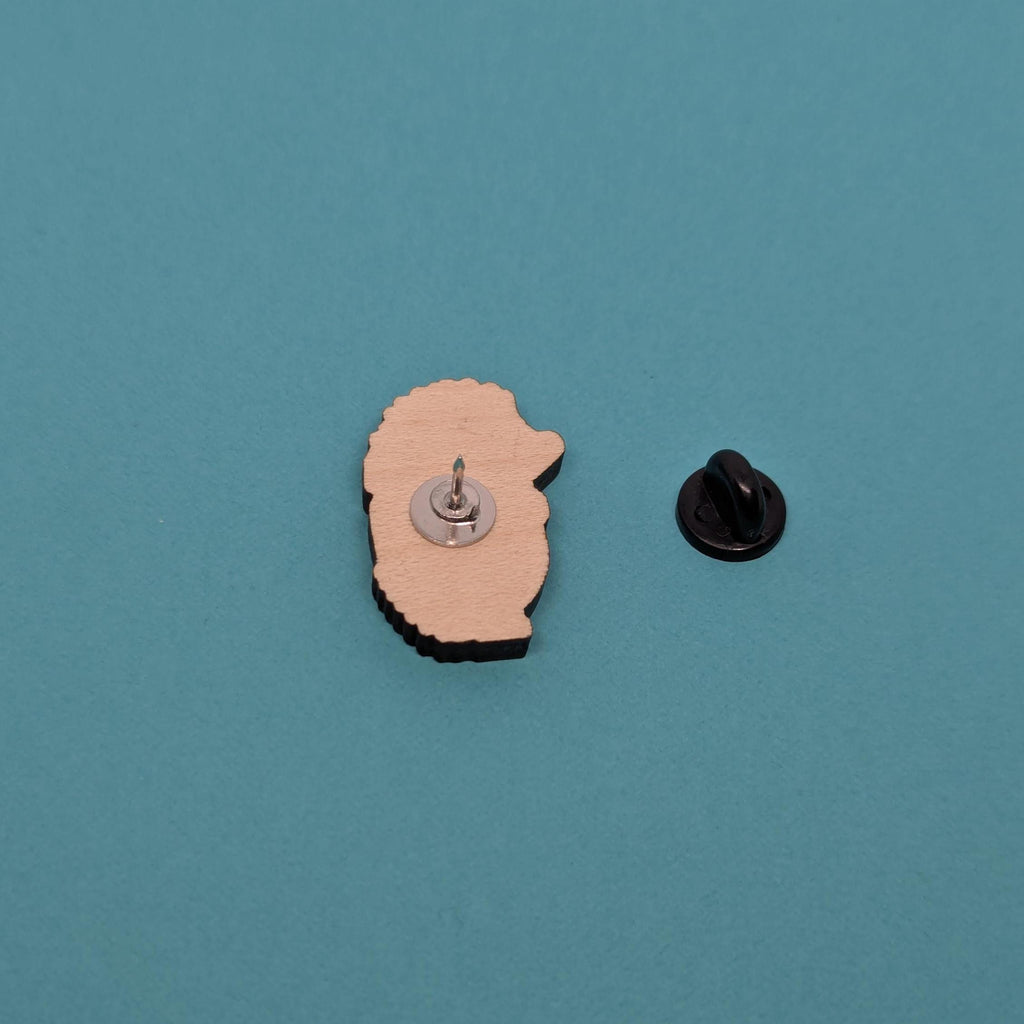 hedgehog shaped wooden pin back on a blue background