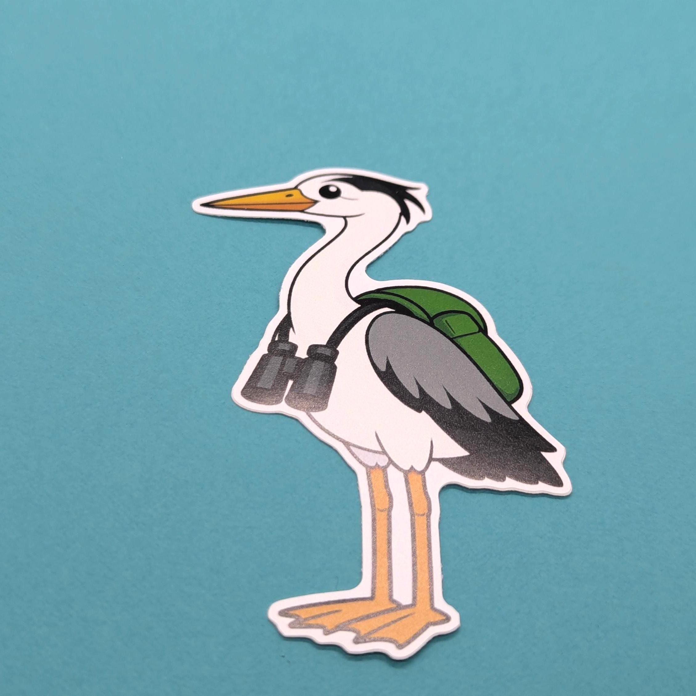 Sticker of a heron with binoculars and a backpack on a teal background