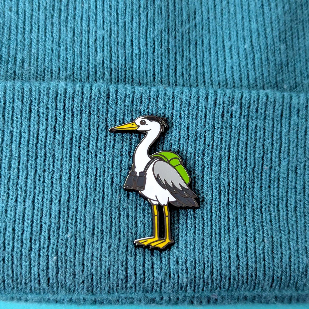 heron pin on a textured blue fabric background