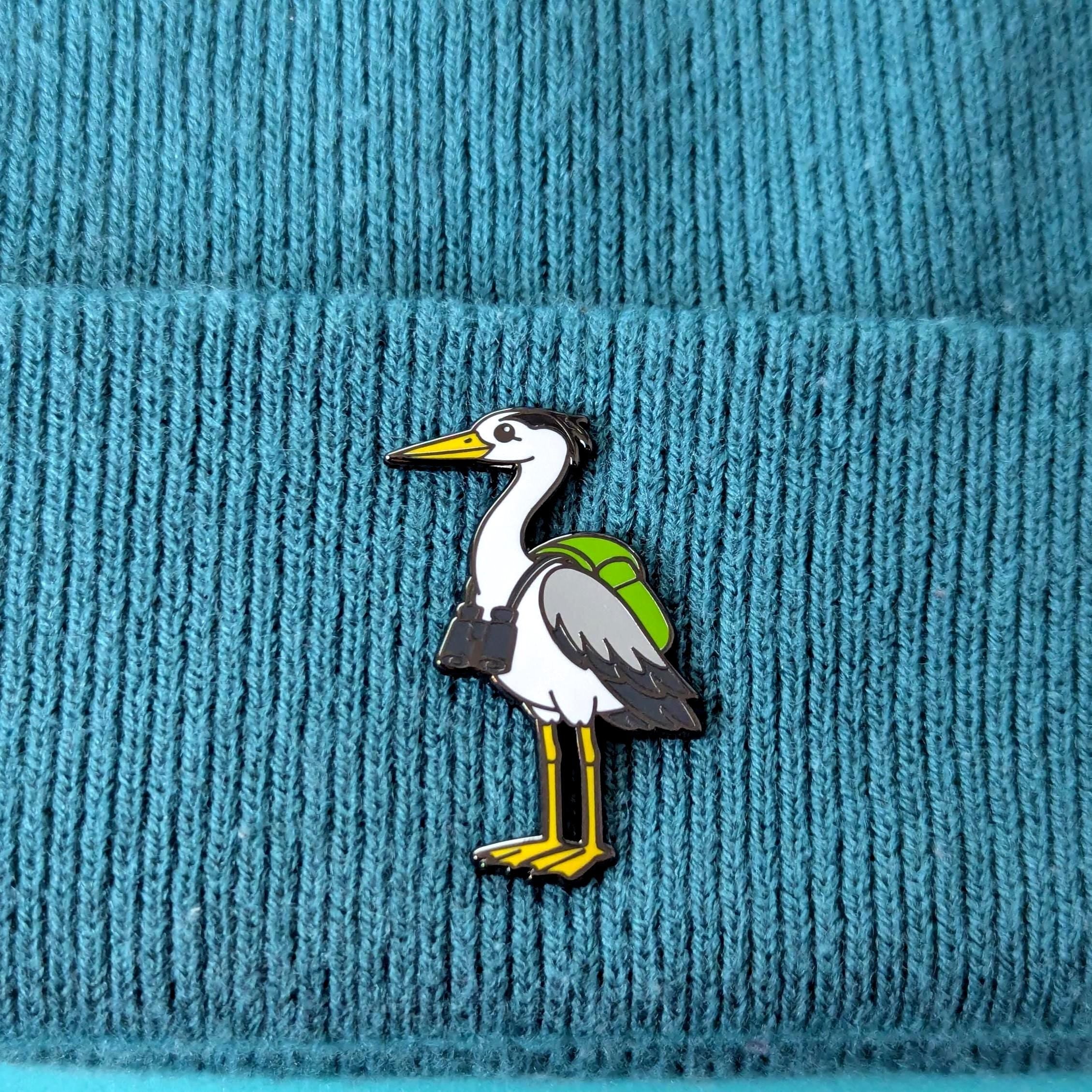 heron pin on a textured blue fabric background