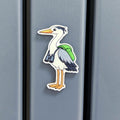 Fridge magnet of a heron with binoculars on a grey surface