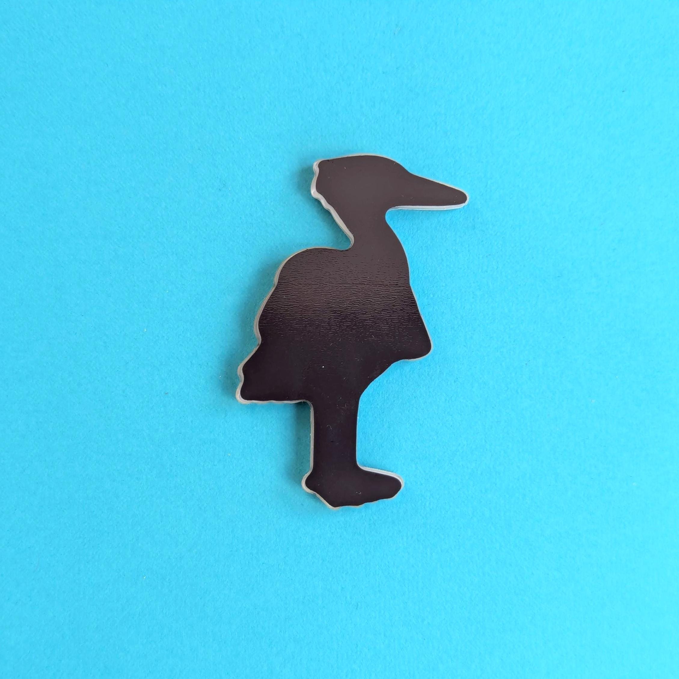 Back view of heron fridge magnet on blue background