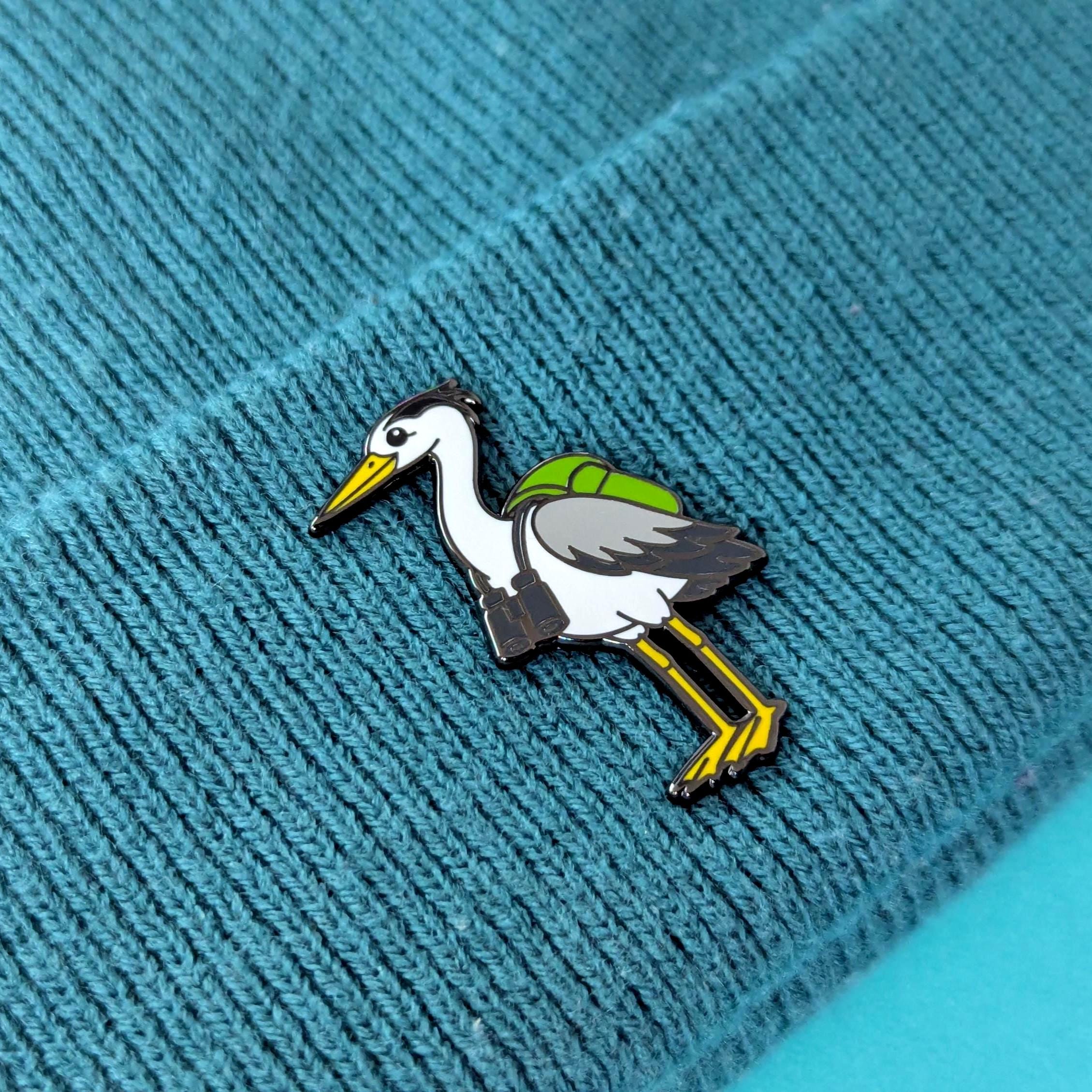 heron pin on a textured blue fabric background