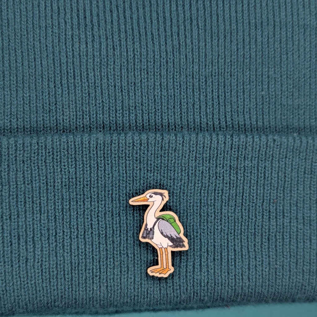 Heron wooden pin on a teal knitted fabric background