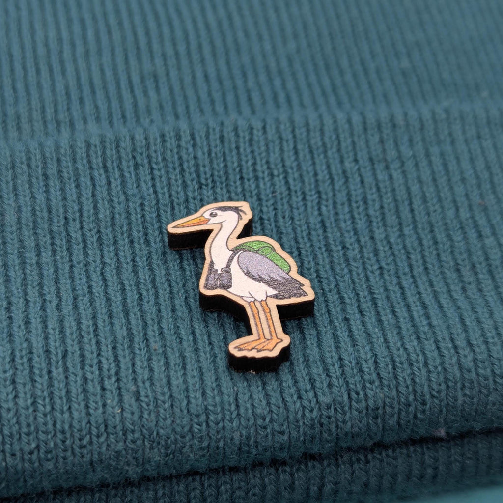 Heron wooden pin on a textured teal fabric background