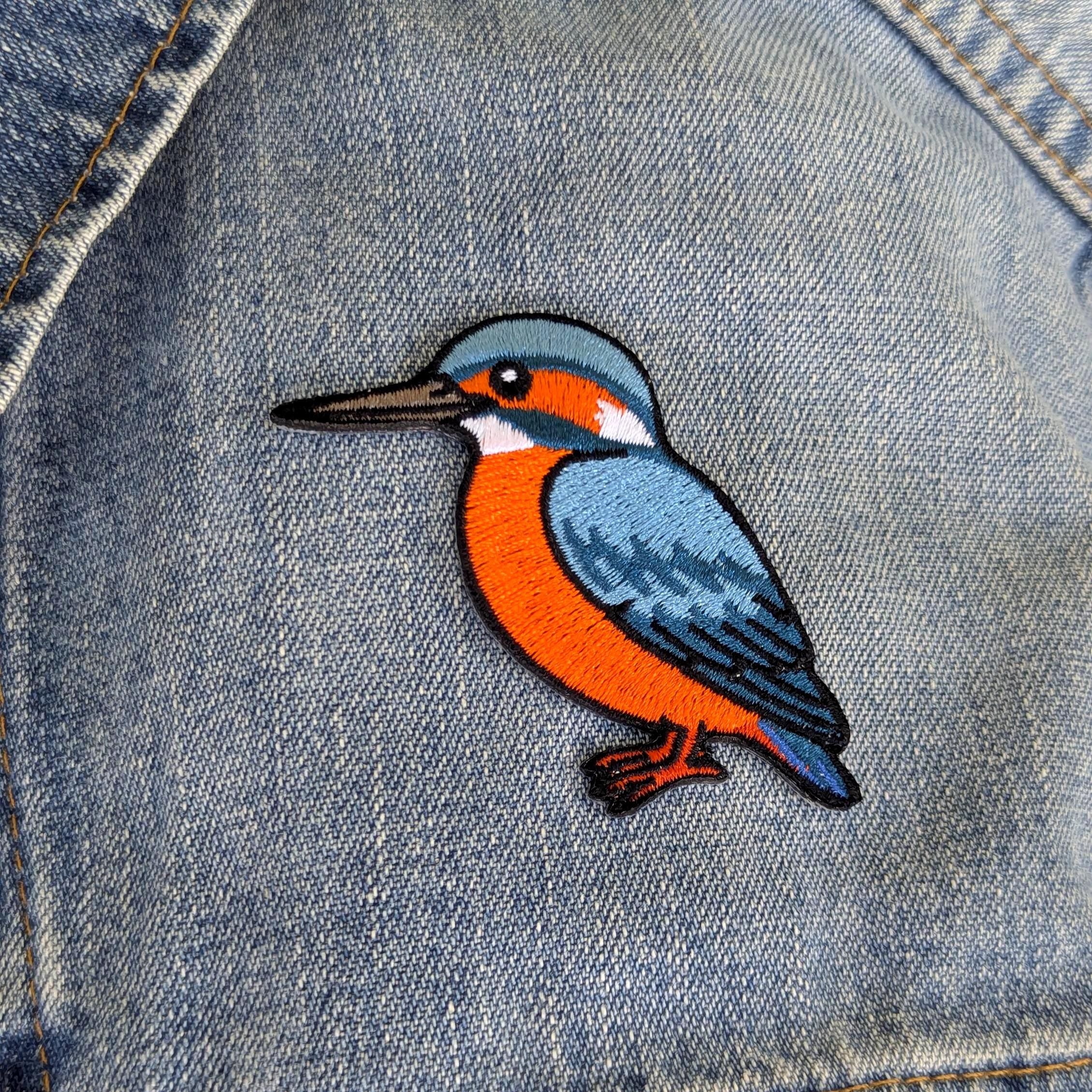 Colourful kingfisher bird patch on a denim background