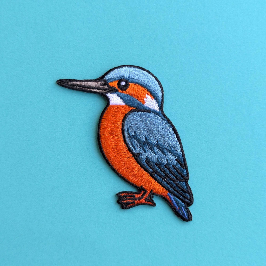 Embroidered patch of a kingfisher bird on a blue background