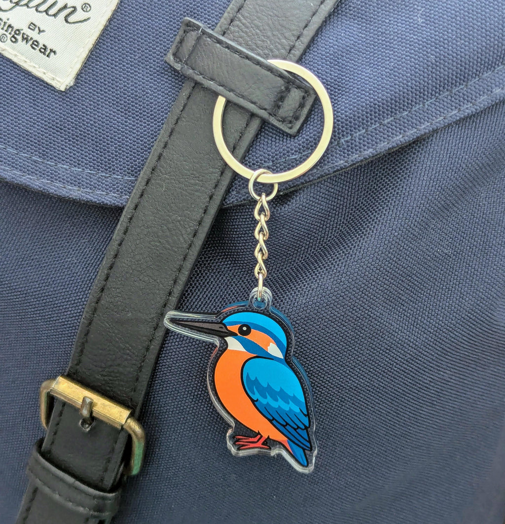 Keychain with a kingfisher bird design attached to a blue bag