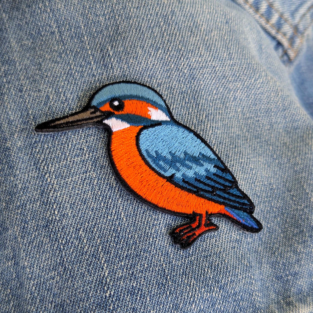 Colourful kingfisher bird patch on a denim background