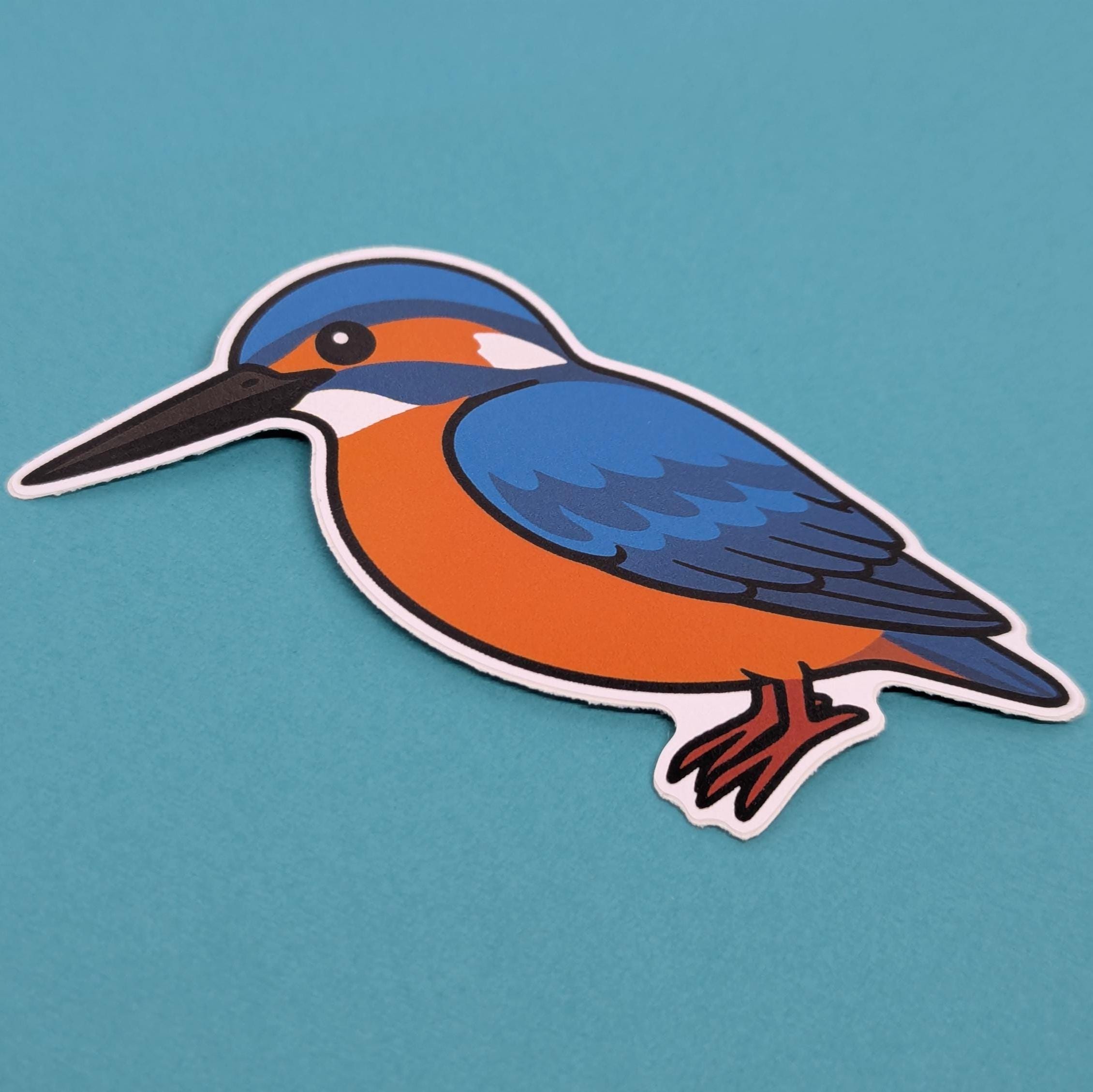 Sticker of a blue and orange kingfisher bird on a teal background