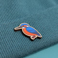 kingfisher wooden pin on a textured teal fabric background